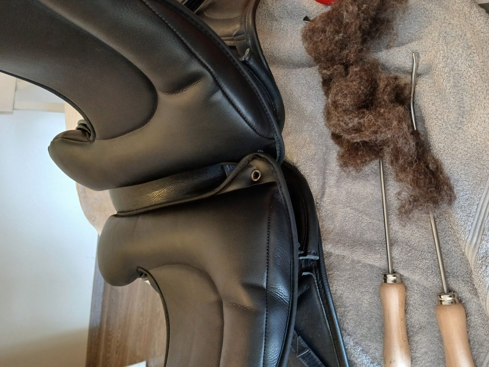 Réglage d'une selle : laine de rembourrage et outils de flocage
